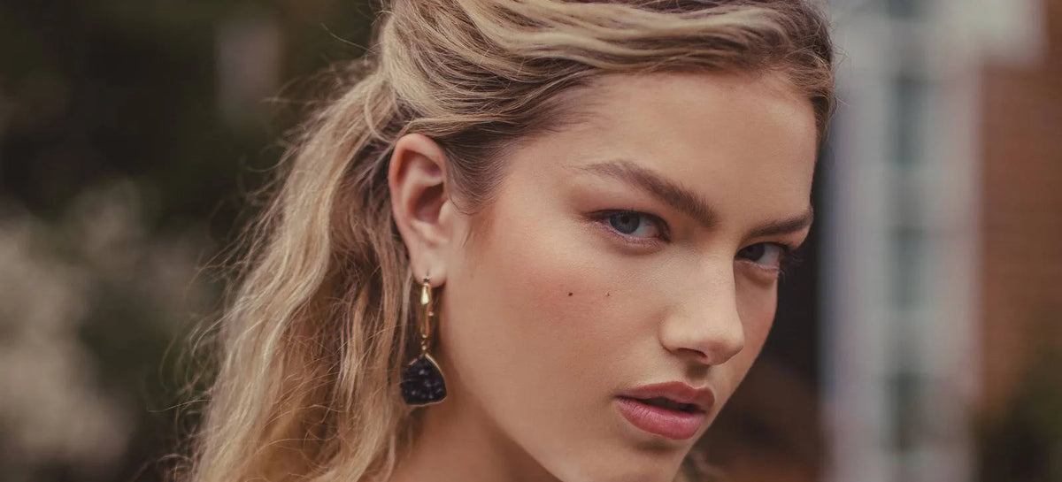Canon RF 45mm f1.2 close-up portrait of a woman with wavy blonde hair and a drop earring, edited with the New York preset