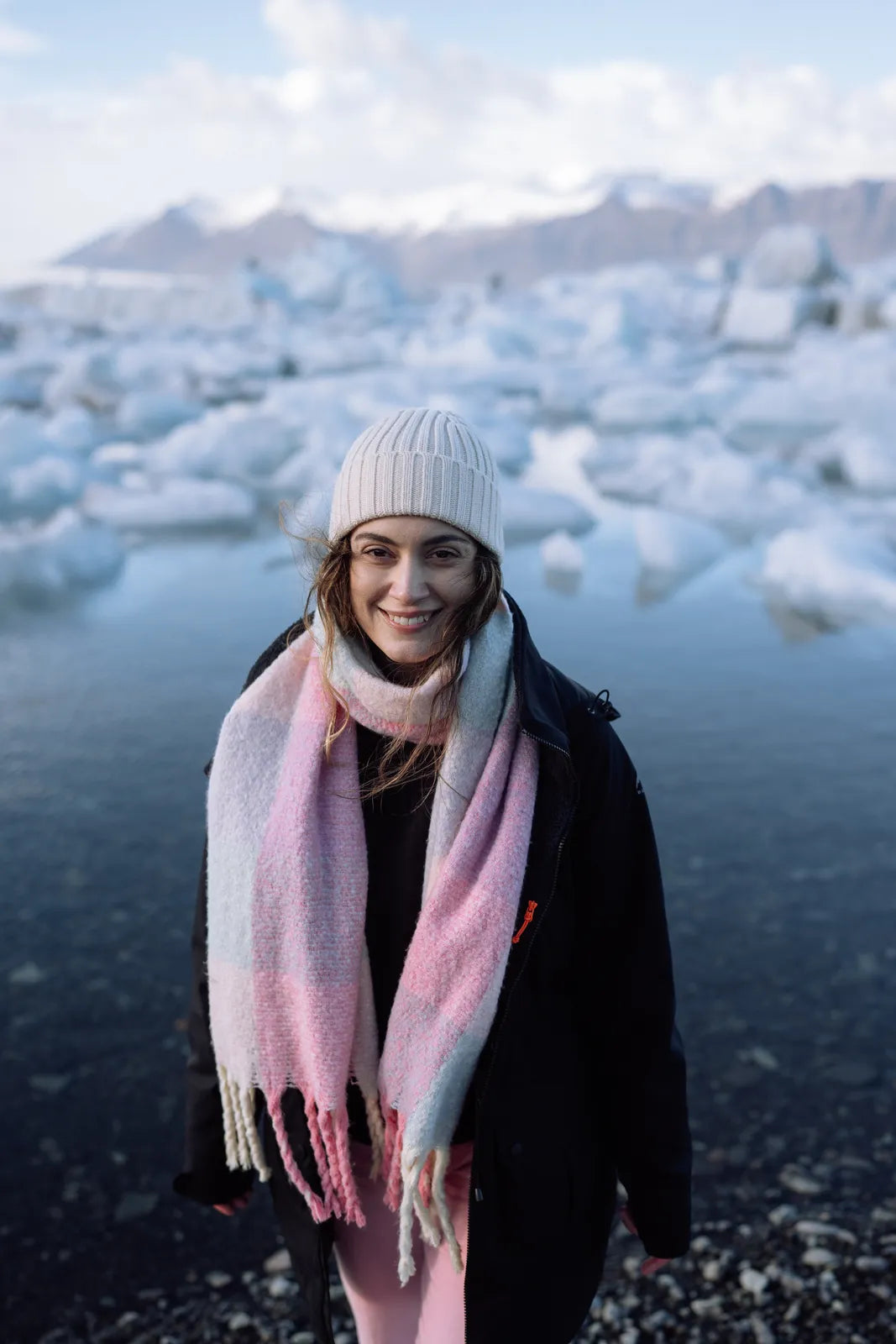 Smiling woman in a beanie at Jökulsárlón glacier lagoon