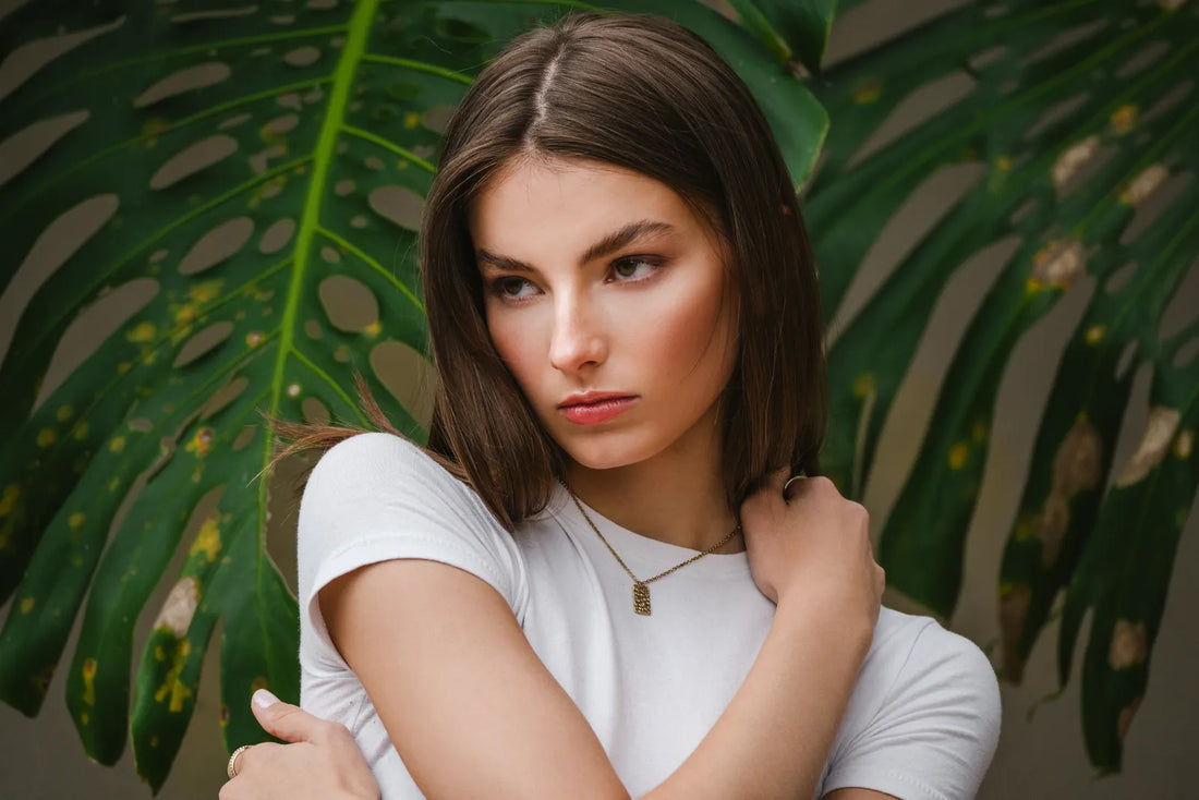 Portrait of a woman in a white t-shirt in front of monstera leaves, shot on the Tamron 70-300mm and Nikon Z8